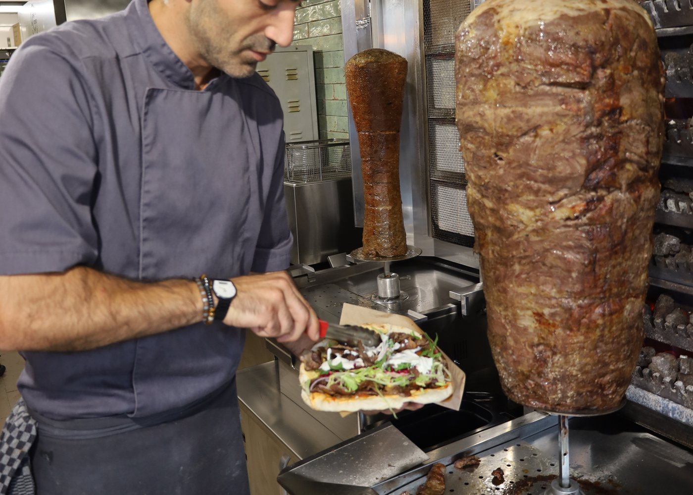 Frisch belegter Döner wird vom Koch fertiggestellt